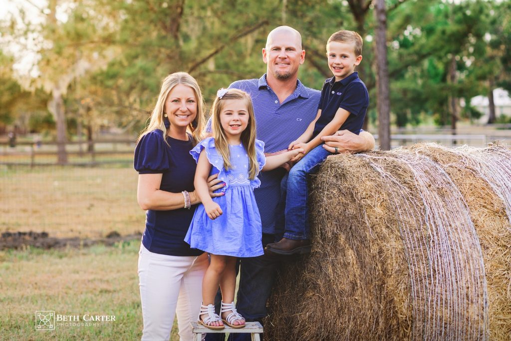 family photo posed on a hay roll