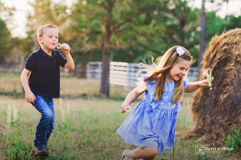 children chasing each other around the hay