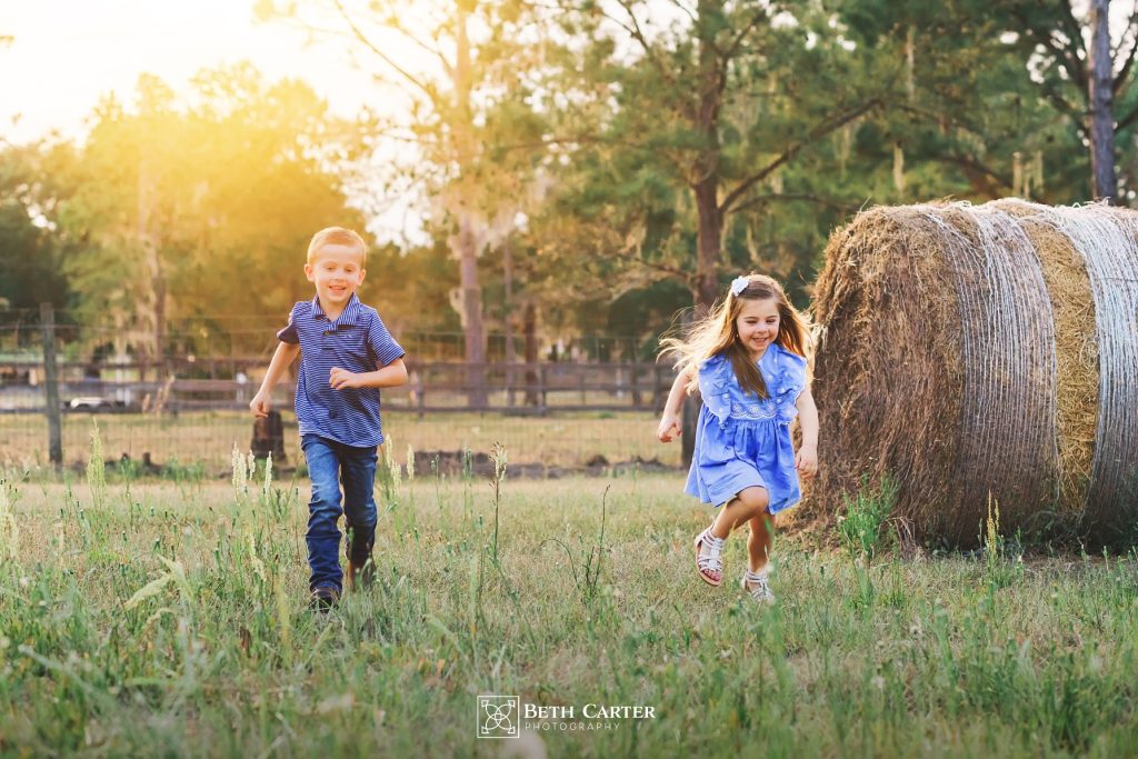 children chasing each other around the hay